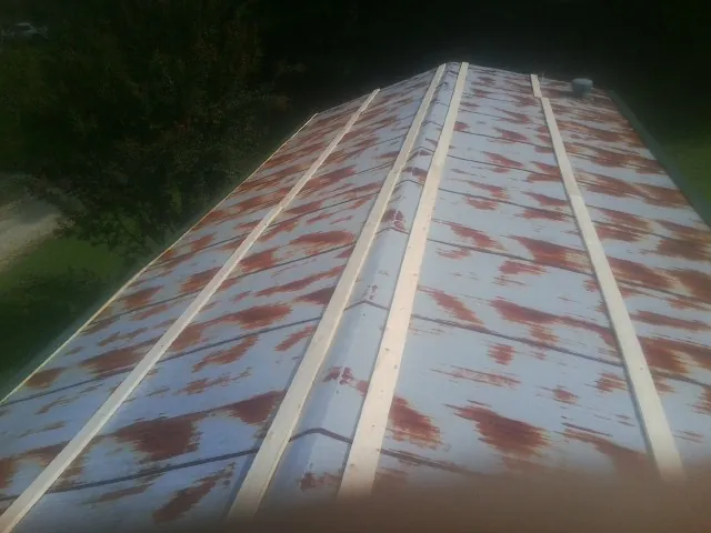 Rusted metal roof panels with new wood purlins before replacement — Storm Damage Roof Repair in Harlingen by Roofing Brothers