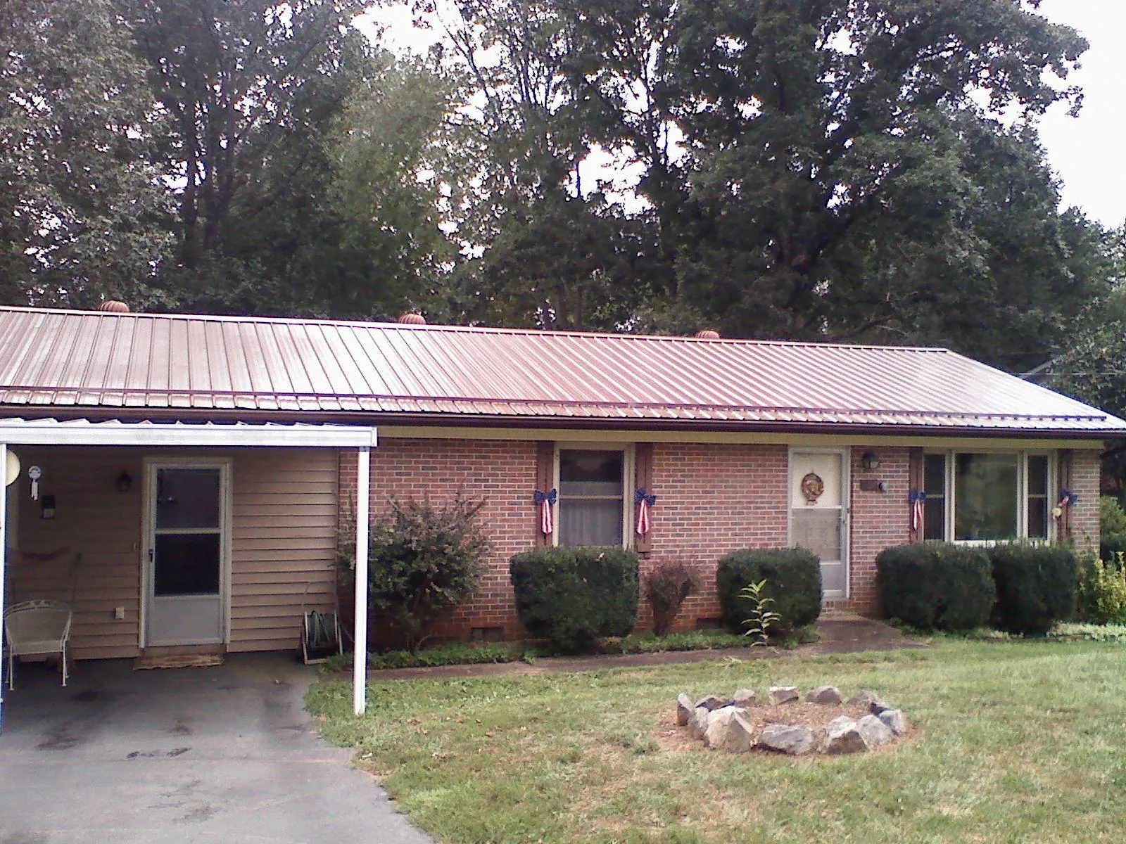 Bronze metal roof and carport on a brick ranch home — Roof Repair work by our crew in Harlingen